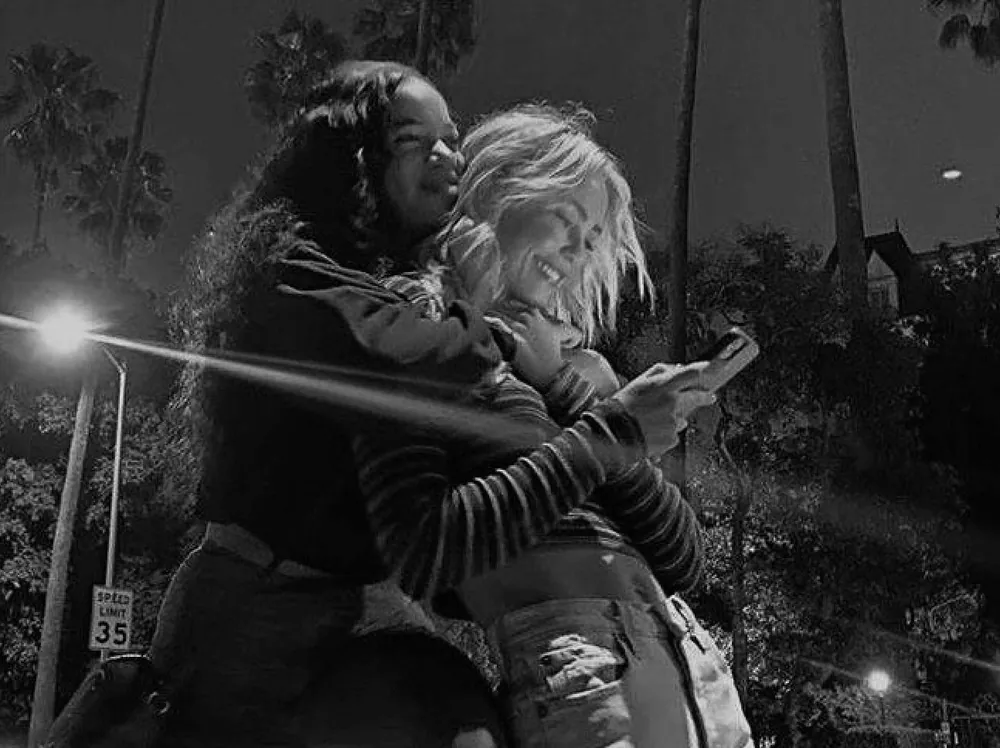 Two women embracing in black and white