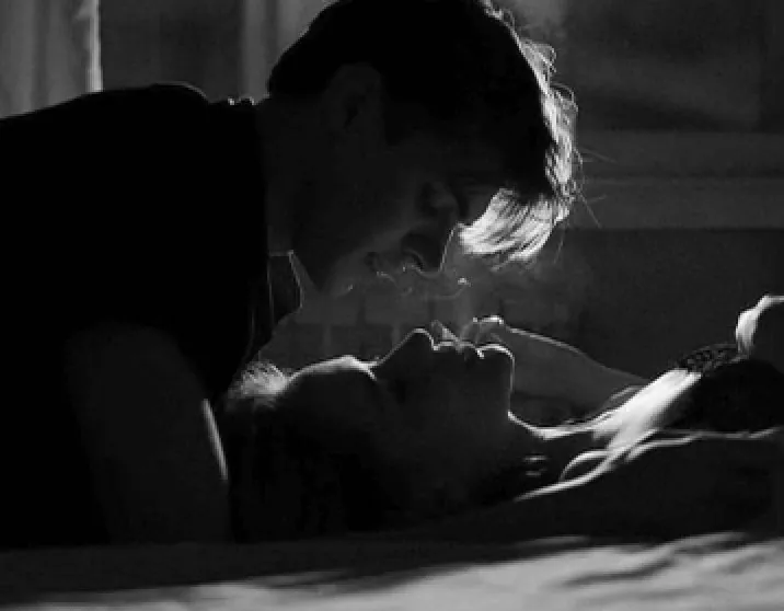 A couple about to kiss in soft black and white light